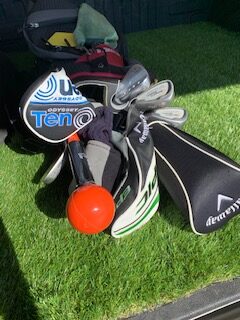Golf bag laying flat with image of the clubs at the top. 