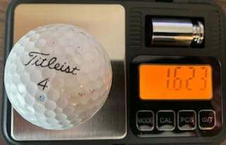 pond titleist ball on scale weighing 1.623 ounces.