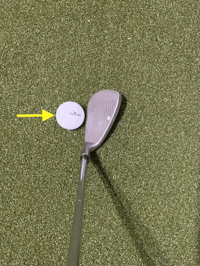 Iron with golf ball and focus on the front of the ball