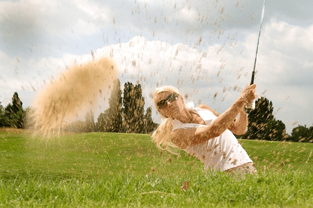 A golfer hitting a golf ball with a golf club
