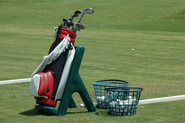 A golfer selecting a golf club from a golf bag