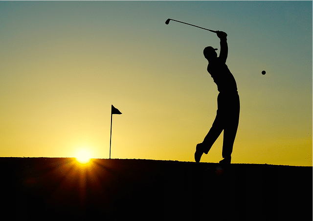 A golfer hitting a golf ball with a golf club