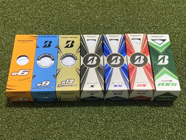 7 Different types of Bridgestone golf balls in the box lined up next to each other. From left to right, e6, e9, e12, X, XS, RX, and RXS.