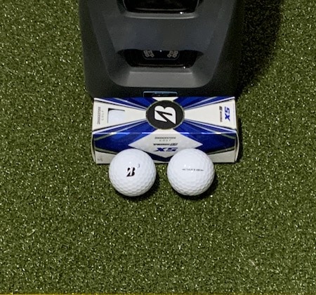 Bridgestone Tour B XS golf balls in front of the GC3 launch monitor.