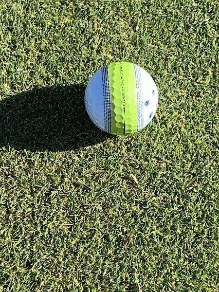 Taylormade Tour Response stripe golf ball on the putting green.