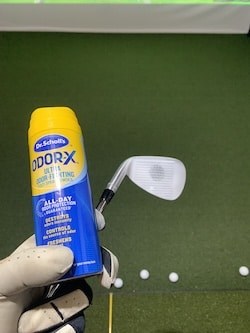 Foot powder spray on golf club with impact location shown in an at home practice session