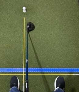 Golf driver with 2 alignment rods with a golf ball on a tee depicting proper alignment.